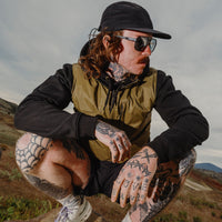Person wearing dark-framed polarized sunglasses in outdoor desert landscape setting