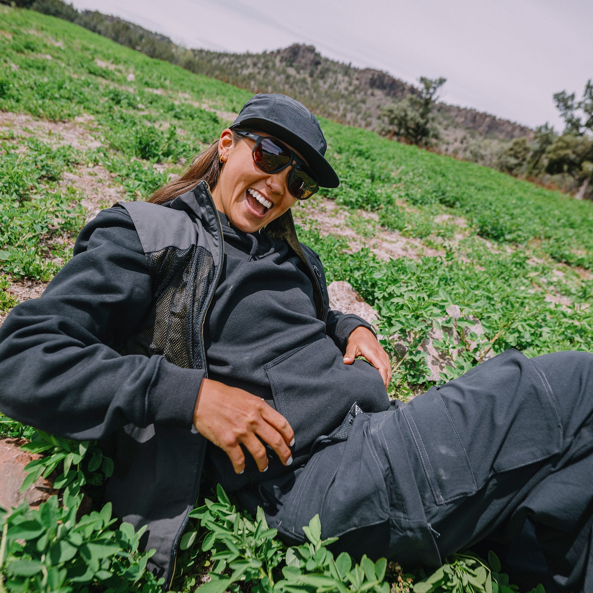 Woman laughing outdoors wearing wraparound sunglasses with tortoise frames and photochromic lenses