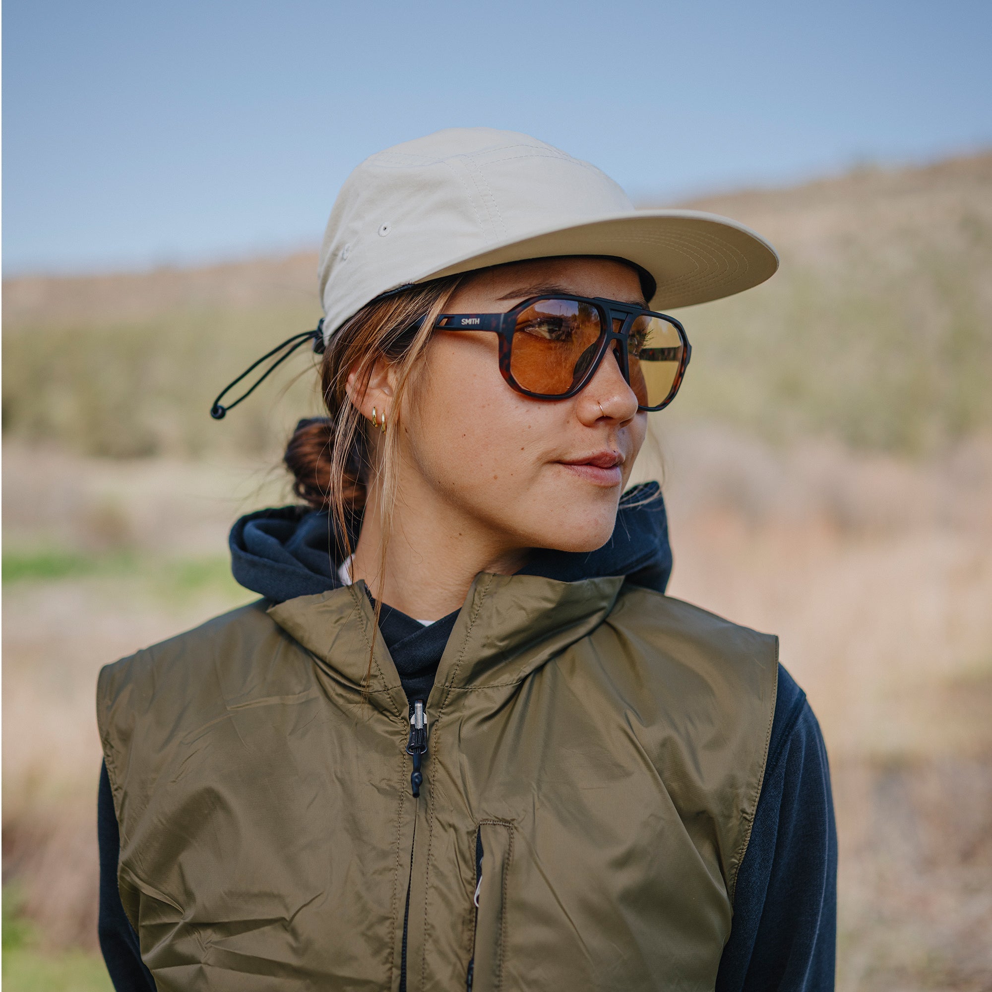Person outdoors wearing aviator-style sunglasses with tortoise frames and amber lenses