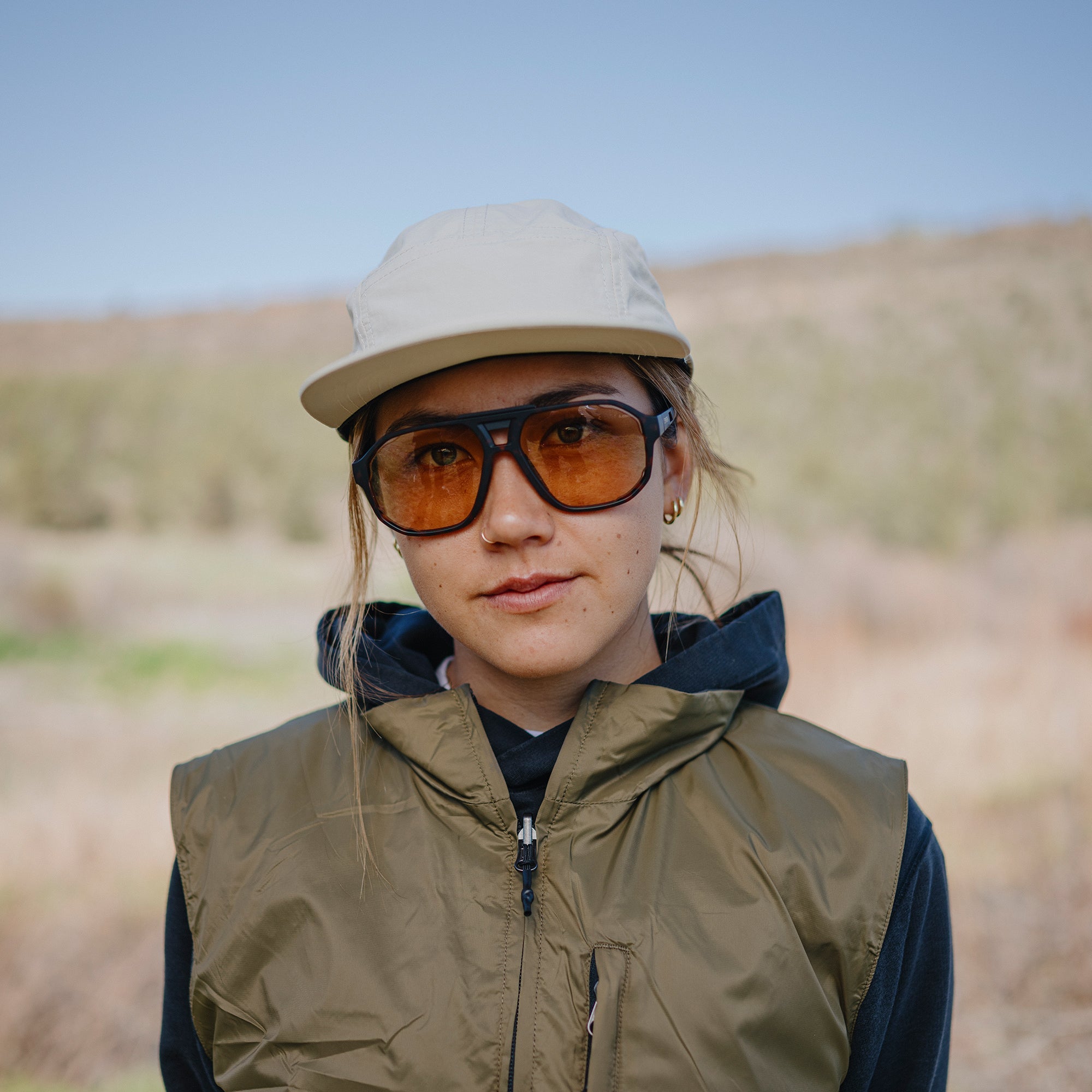 Large oversized sunglasses with black frames and amber photochromic lenses worn outdoors