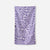 Purple towel with white daisy flower pattern laid flat on white background