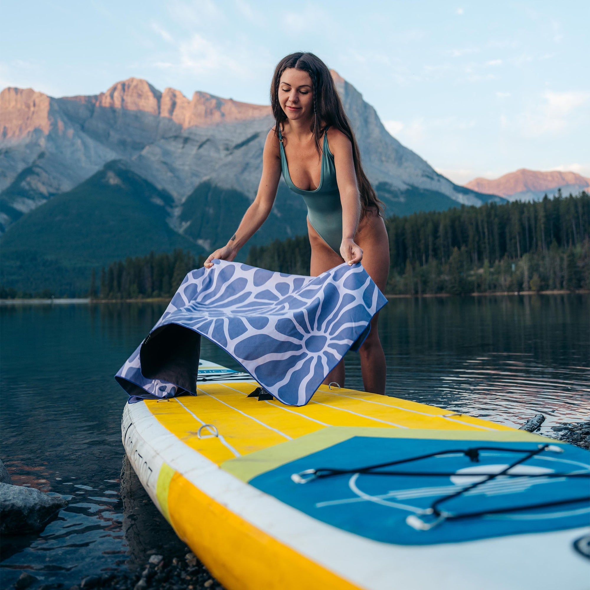 Quick-dry towel with blue and white sun pattern being held by person on paddleboard