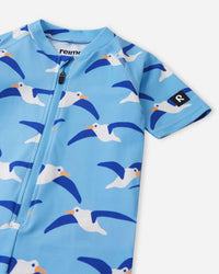 Children's short-sleeve zip-up swimsuit with seagull print on light blue background, detail view