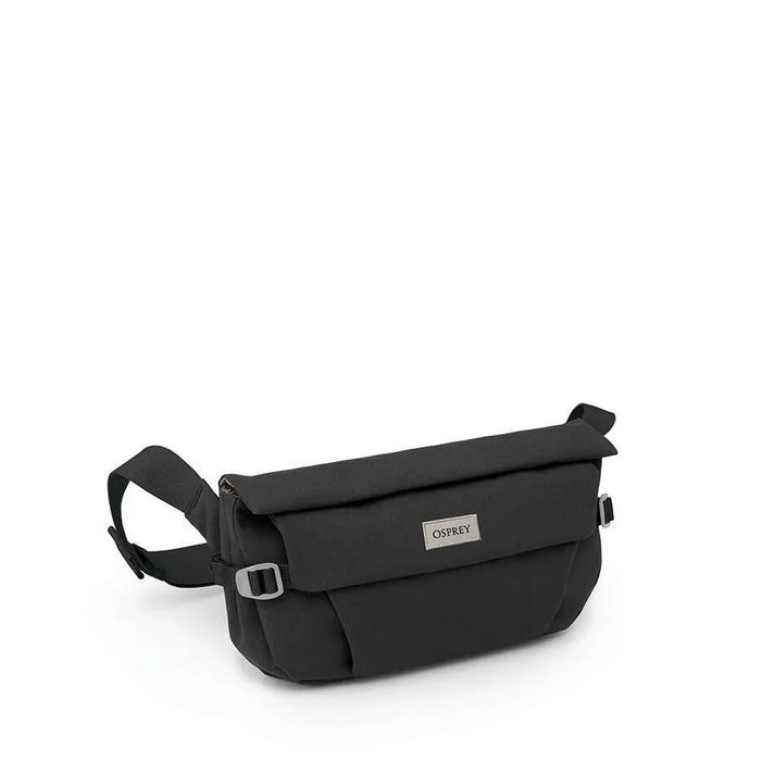 Small black crossbody hip bag with flap closure, adjustable strap, and metal logo badge