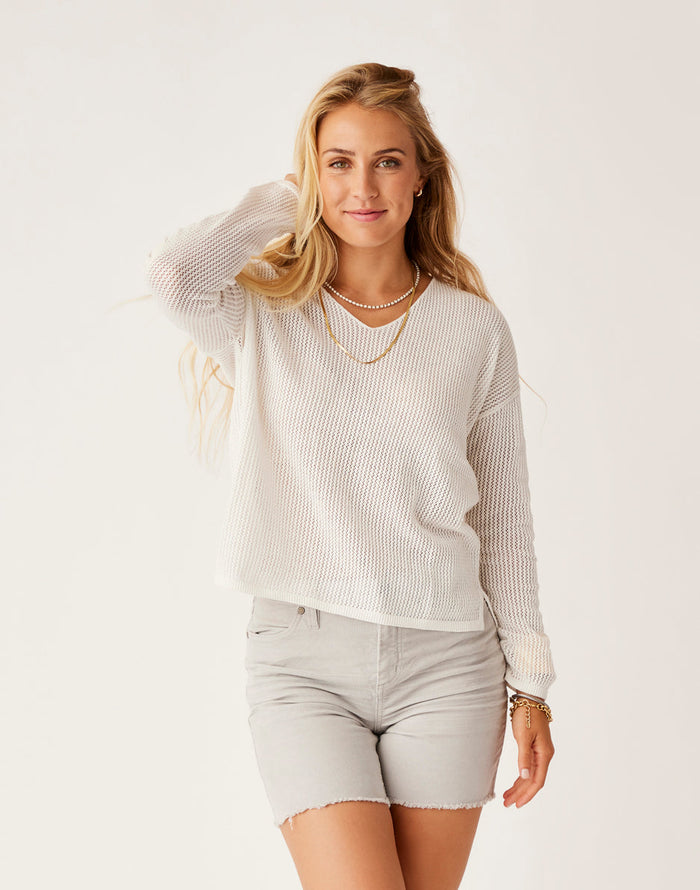Woman wearing cream mesh knit pullover sweater with v-neck and long sleeves